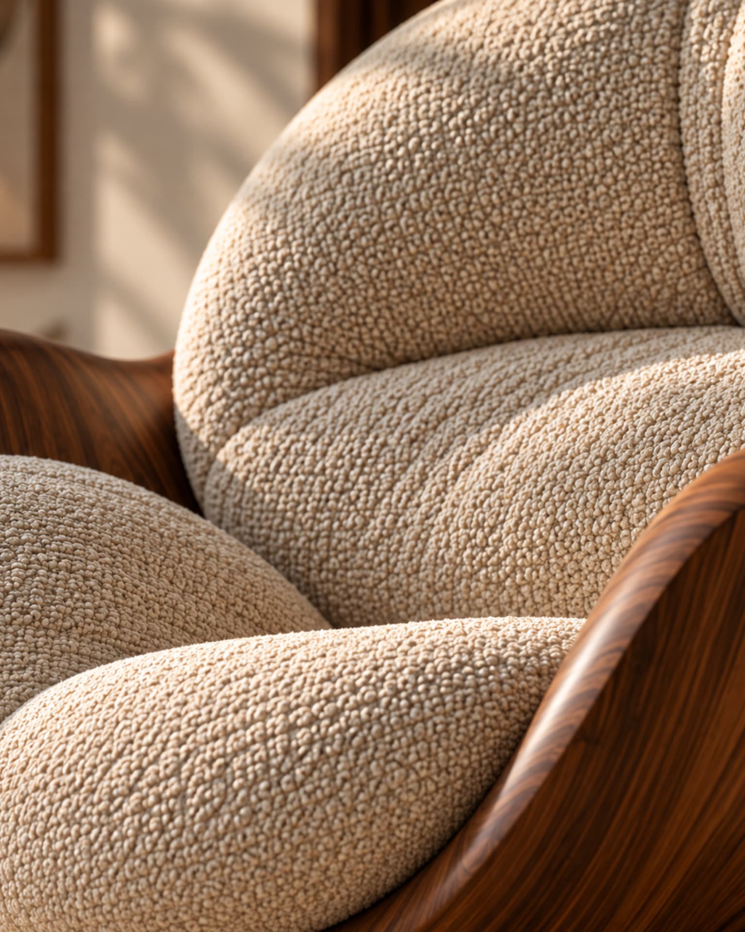 Close detail of the bouclé upholstery and curved wooden arm