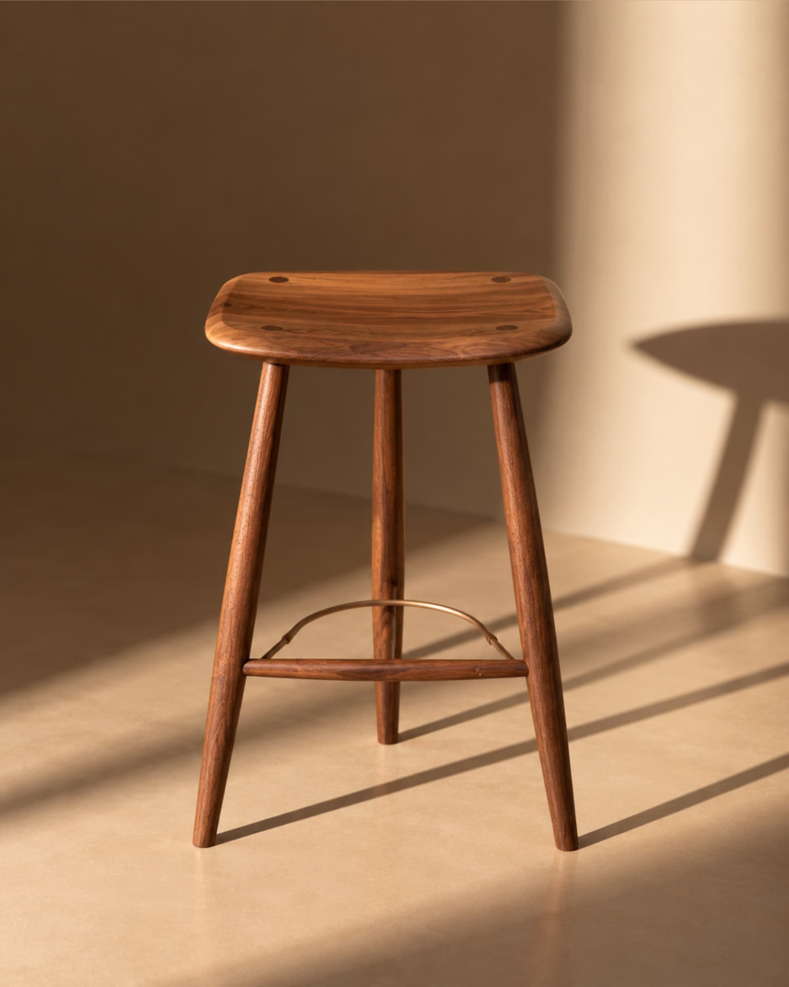 Front view of the walnut stool in directional light